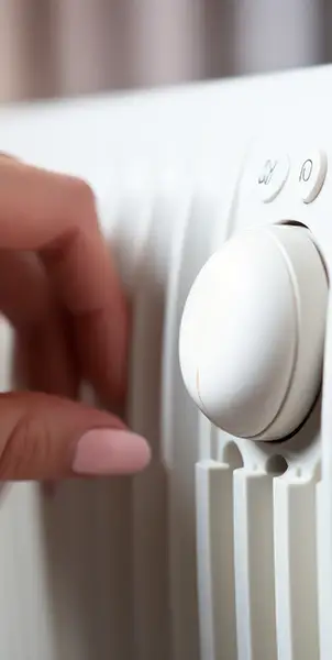 Energieffiziente Nutzung einer Gastherme - Hand am Thermostat